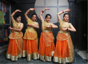 Four women performing traditional Indian dance on stage